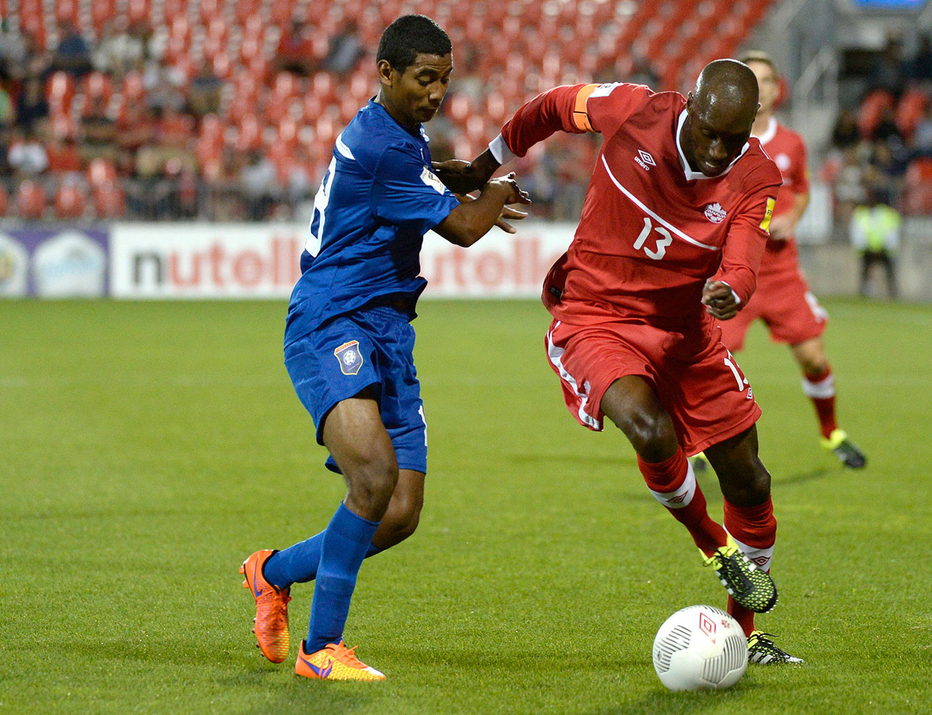 Atiba Hutchinson (red, on the right) in 2018 FIFA World Cup qualifying action against Belize in Toronto on September 4, 2015.