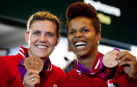 Female soccer players posing with medals