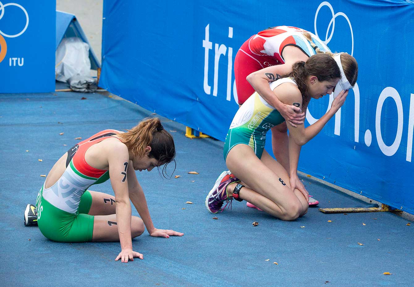 Kirsten Sweetland (standing) helps competitor and friend Ashleigh Gentle of Australia after an ITU race in Edmonton on Sunday, September 6. Race was extremely cold, with temperatures as low as seven degrees Celsius.