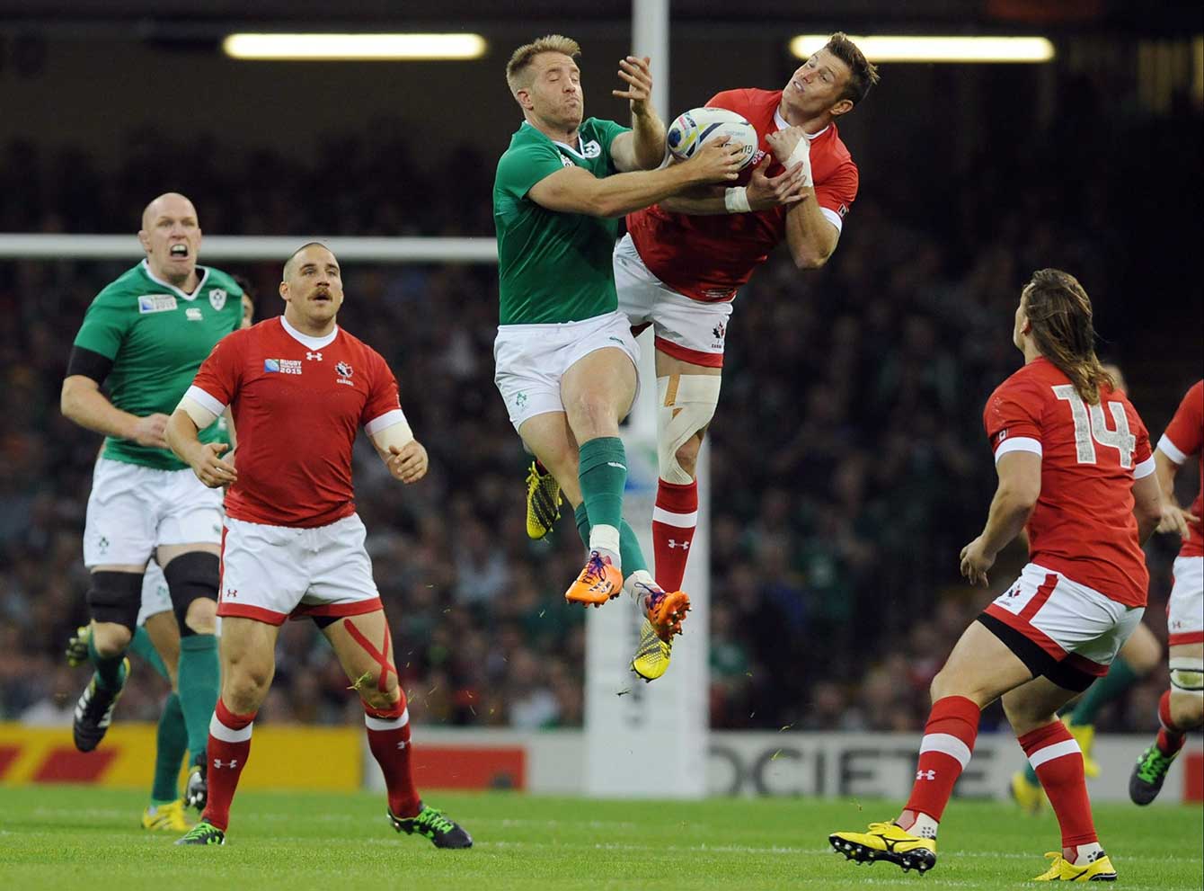 Ireland's Luke Fitzgerald, centre left, and Canada's Matt Evans compete for the ball during their Rugby World Cup Pool D match at the Millennium Stadium, Cardiff, Wales, Saturday Sept. 19, 2015. (AP Photo/Rui Vieira)