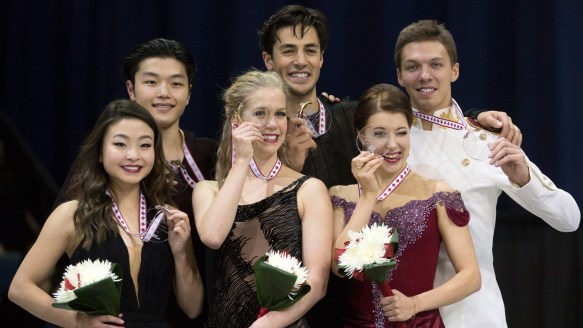 Kaitlyn Weaver and Andrew Poje (centre) receive their first place medals at Skate Canada International on October 31, 2015.