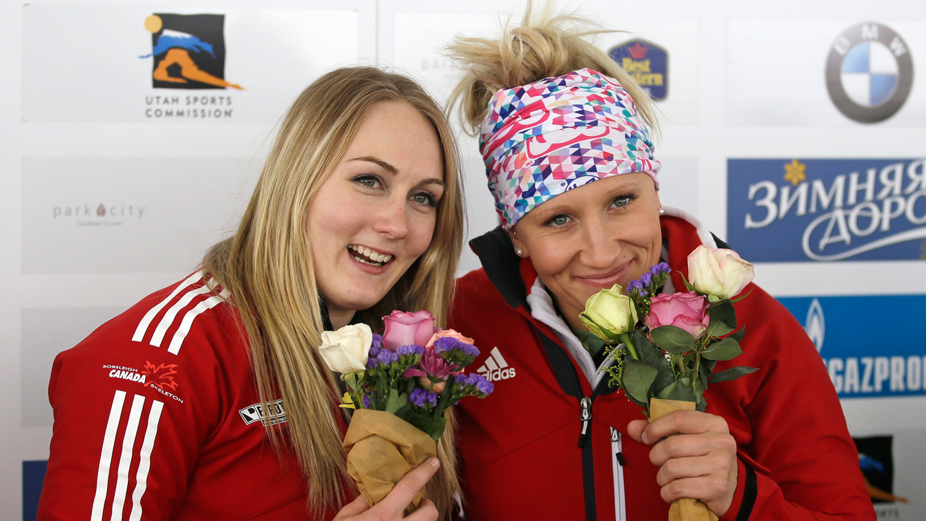 Kaillie Humphries, right, and Melissa Lotholz pose with their flowers during a ceremony after winning the women's bobsled World Cup race Friday, Jan. 15, 2016, in Park City, Utah. (AP Photo/Rick Bowmer)