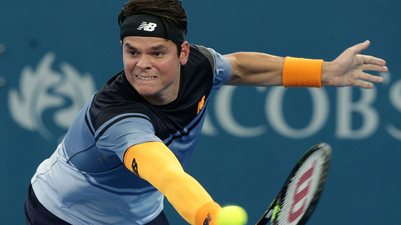 Milos Raonic reaches for a return against Bernard Tomic in the Brisbane International semifinals on January 9, 2016.