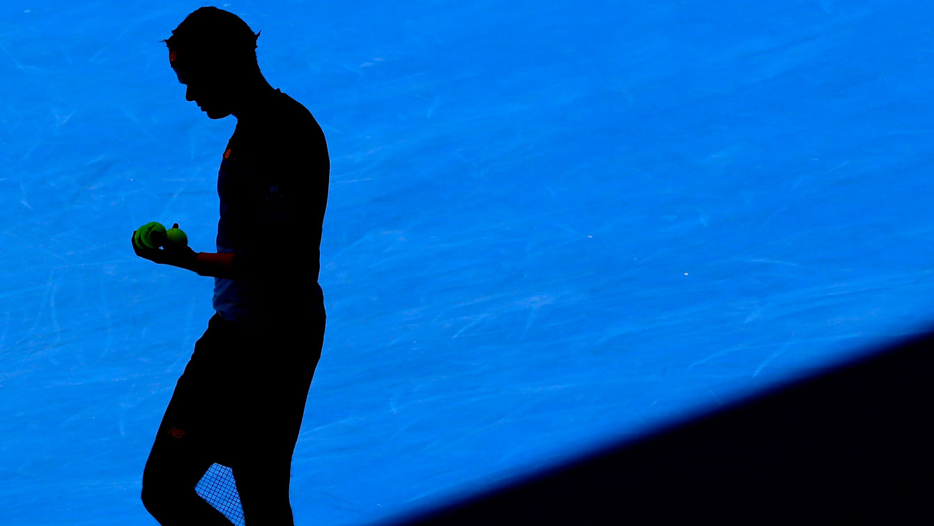 The mid-afternoon sun in Melbourne puts a shadow over Milos Raonic as he prepared to serve in the Australian Open third round against Viktor Troicki on January 23, 2016.