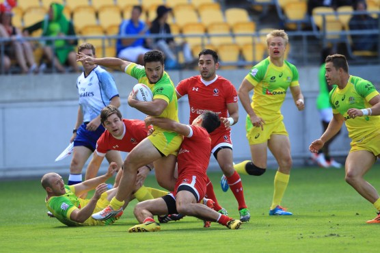 Canadian players tie up an Australian player in a tackle. (Photo: Martin Seras Lima)