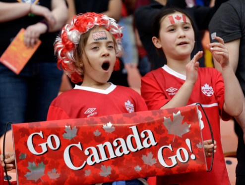 10744664 Two young Team Canada fans cheer for Canada's women's soccer team as they take the field for a CONCACAF Olympic qualifying tournament soccer match against. (AP Photo/David J. Phillip)