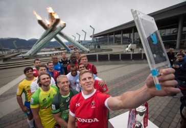 Team Canada captain John Moonlight, front right, uses a Twitter mirror to take a photo of himself with other team captains at the Olympic cauldron to promote the World Rugby Sevens Series' Canada Sevens tournament, in Vancouver, B.C., on Tuesday March 8, 2016. The two day tournament is scheduled to be held March 12 and 13. THE CANADIAN PRESS/Darryl Dyck