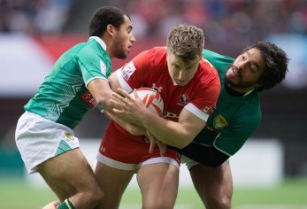 Canada's Lucas Hammond, centre, is tackled by Brazil's Laurent Couhet, left, and Moises Duque during World Rugby Sevens Series' Canada Sevens tournament action, in Vancouver, B.C., on Sunday March 13, 2016. THE CANADIAN PRESS/Darryl Dyck