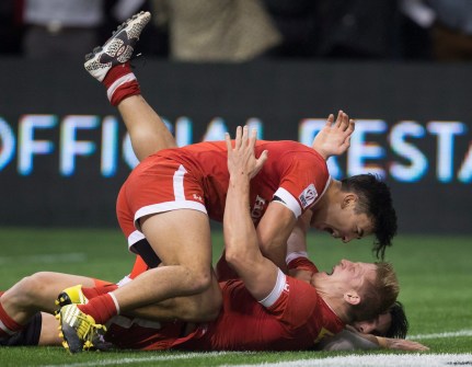 Canada's Nathan Hirayama, top, and John Moonlight celebrate after Moonlight scored the winning try in the final moments of play against France during World Rugby Sevens Series' Canada Sevens bowl final action, in Vancouver, B.C., on Sunday March 13, 2016. THE CANADIAN PRESS/Darryl Dyck