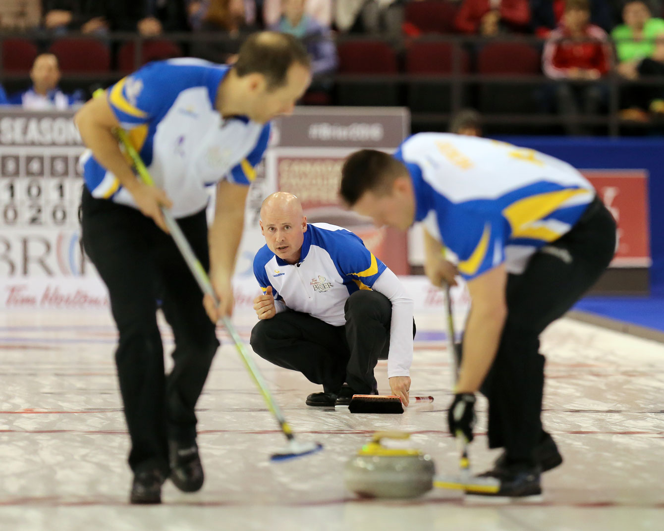Kevin Koe (centre) guides a shot at the Brier on March 13, 2016 (Photo: Greg Kolz). 