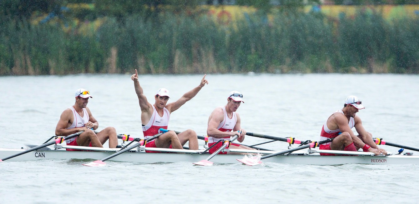 Canadians, left to right, Matthew Buie, Julien Bahain, with arms raised, Dean Will, and Rob Gibson coast in their boat after winning gold in the men's quadruple sculls at the 2015 Pan Am Games at the Royal Canadian Henley Rowing Course in St. Catharines, Ontario on Tuesday, July 14, 2015. THE CANADIAN PRESS/Peter Power