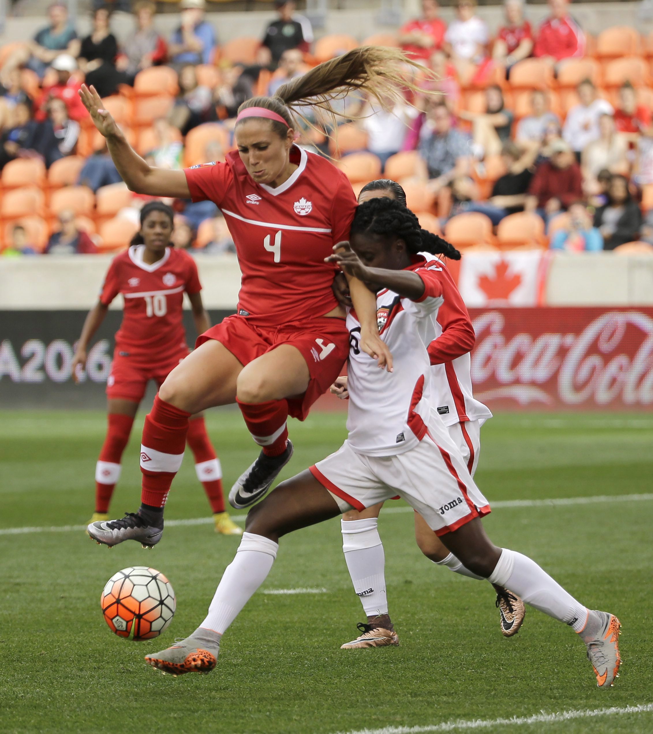 Canada's Shelina Zadorsky (4) jumps over the leg of Trinidad & Tobago's Khadidra Debesette (6) during the first half of a CONCACAF Olympic qualifying tournament soccer match Sunday, Feb. 14, 2016, in Houston. Canada won 6-0. (AP Photo/David J. Phillip)