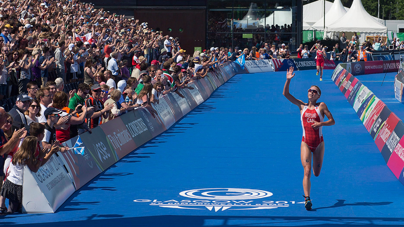 Canada's Kirsten Sweetland from Victoria, B.C., races to a silver medal in the women's triathlon at Strathclyde Country Park in Glasgow, Scotland on Thursday, July 24, 2014. The medal is Canada's first at the Games. (THE CANADIAN PRESS/Andrew Vaughan)