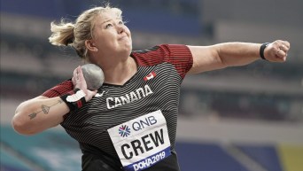 Brittany Crew with shot put by neck ready to throw