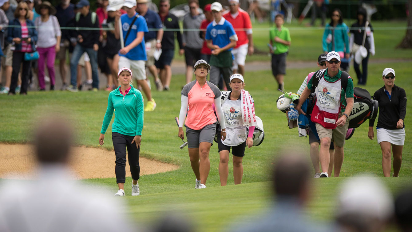 Brooke Henderson (in green, left) walks on to the second hole green with Mariajo Uribe of Colombia (in pink) at the Portland Classic on July 3, 2016. 