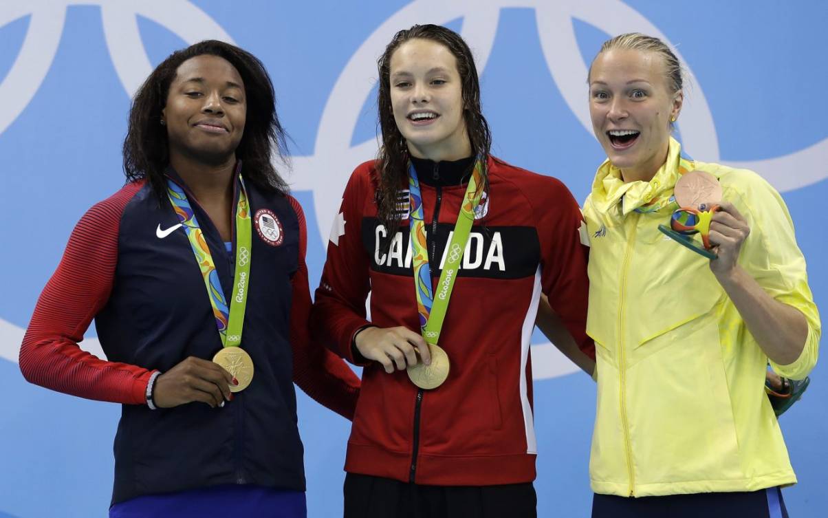 Gold medal winners United States' Simone Manuel and Canada's Penny Oleksiak and Sweden's bronze medal winner Sarah Sjostrom, from left, pose for a photograph during the medal ceremony for the women's 100-meter freestyle final during the swimming competitions at the 2016 Summer Olympics, Friday, Aug. 12, 2016, in Rio de Janeiro, Brazil. (AP Photo/Michael Sohn)