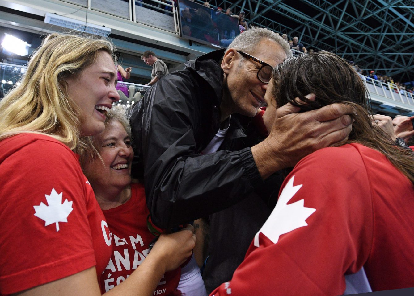 Canada's Penny Oleksiak, right, celebrates with a kiss from her father as her sister and mom look on following her gold-medal performance at the women's 100m freestyle finals during the 2016 Olympic Summer Games in Rio de Janeiro, Brazil, on Friday, Aug. 12, 2016. THE CANADIAN PRESS/Sean Kilpatrick