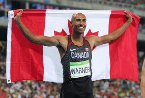Damian Warner holds a Canadian flag