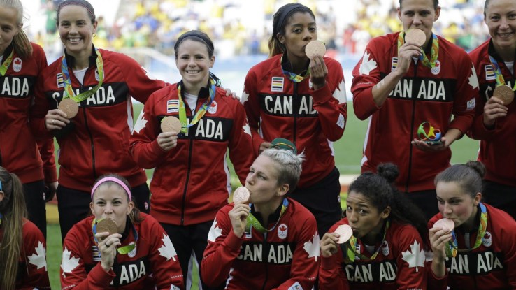 Canadian women's soccer team kiss their medals
