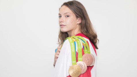 Penny Oleksiak Canada's Penny Oleksiak poses with her medals on the flag at the Olympic games in Rio de Janeiro, Brazil, Sunday August 21, 2016. COC Photo/Mark Blinch