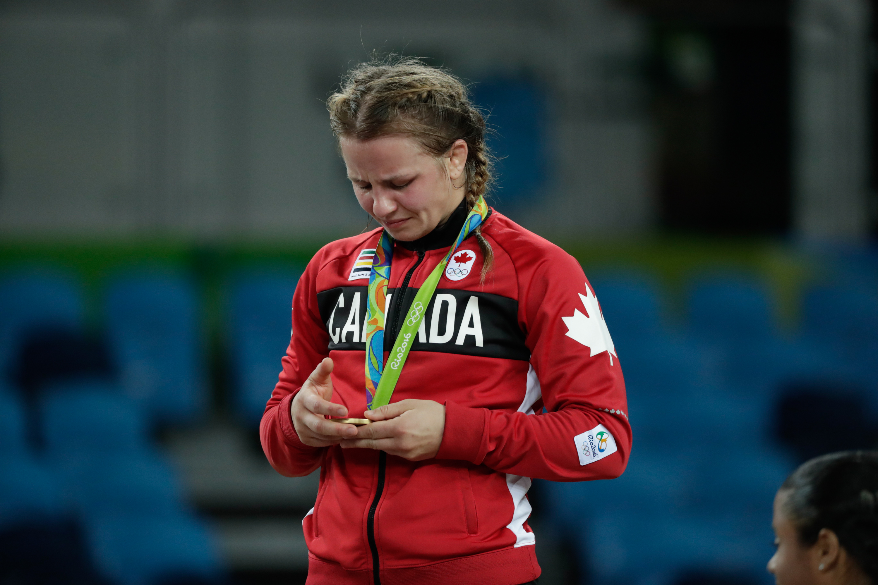 Erica Wiebe looks down at her gold medal while standing on the podium at Rio 2016 (COC/David Jackson)