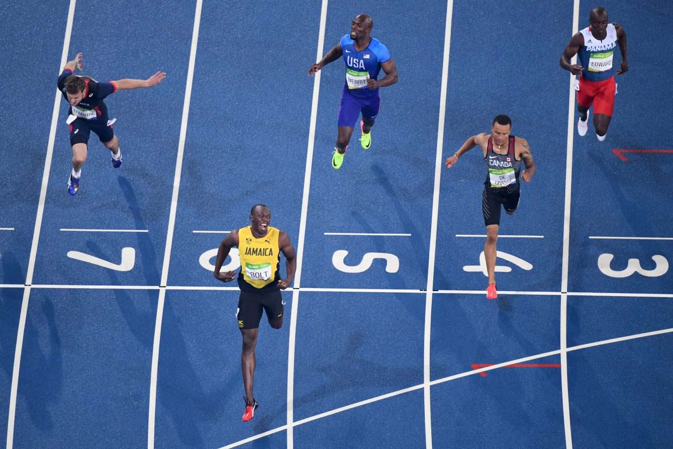 Jamaica's Usain Bolt (2R) crosses the finish line to win the Men's 200m Final during the athletics event at the Rio 2016 Olympic Games at the Olympic Stadium in Rio de Janeiro on August 18, 2016, with Andre De Grasse of Canada finishing second. / AFP / Antonin THUILLIER (Photo credit should read ANTONIN THUILLIER/AFP/Getty Images)