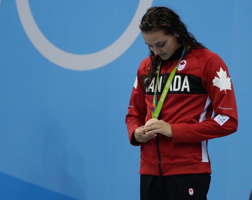 Masse looking down at her Olympic medal