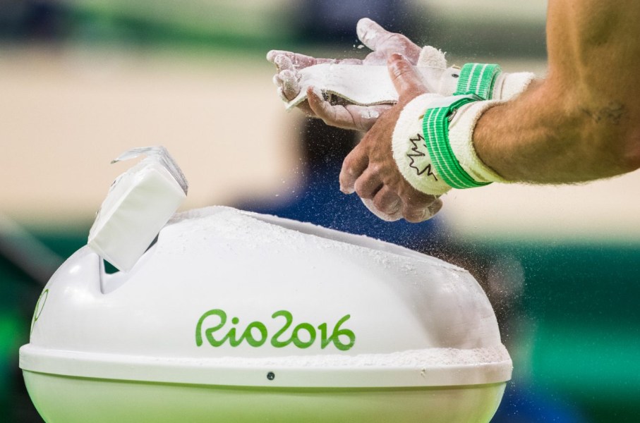 Canada's Scott Morgan puts chalk on his hands before performing on the rings during men's artistic gymnastics qualifying at the Olympic games in Rio de Janeiro, Brazil, Saturday August 6, 2016. COC Photo/Mark Blinch