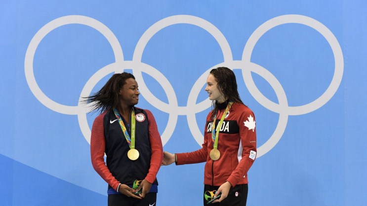 Penny Oleksiak (right) and Simone Manuel atop the Olympic podium at Rio 2016 on August 11, 2016.