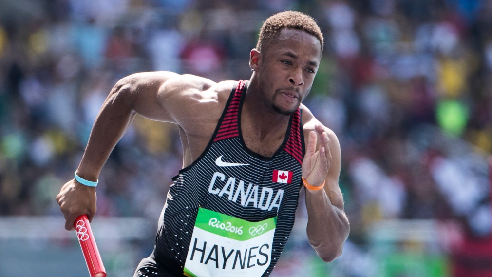 Akeem Haynes sprinting while holding baton