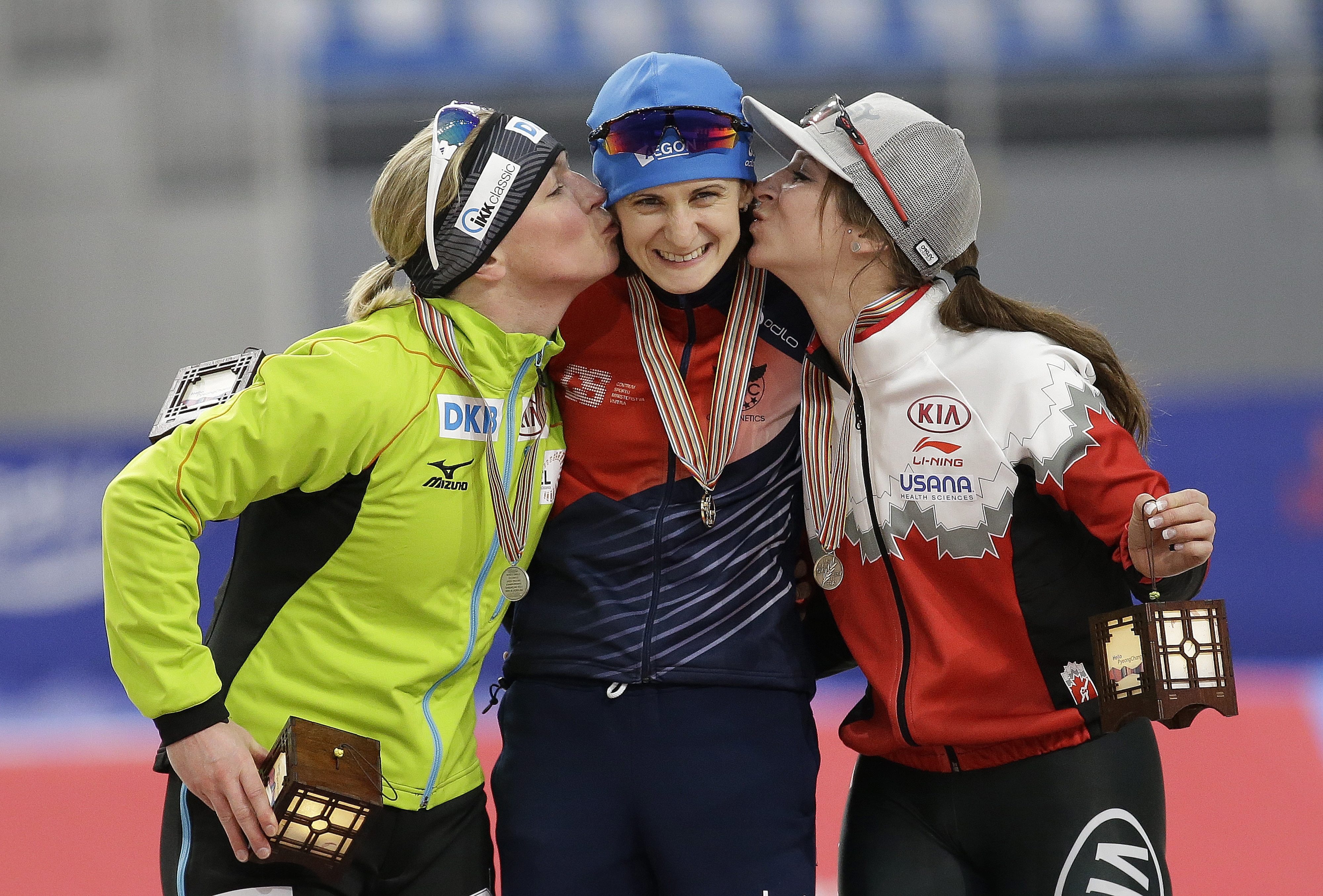 Winner Martina Sablikova of Czech Republic, center, is kissed by second placed Claudia Pechstein of Germany and third placed Ivanie Blondin, right, of Canada during the victory ceremony of the women's 5000 meter race of the ISU world single distances speed skating championships at Gangneung Oval in Gangneung, South Korea, Saturday, Feb. 11, 2017. The world cup competition is also a test event for the upcoming Pyeongchang 2018 Winter Olympics. (AP Photo/Ahn Young-joon)