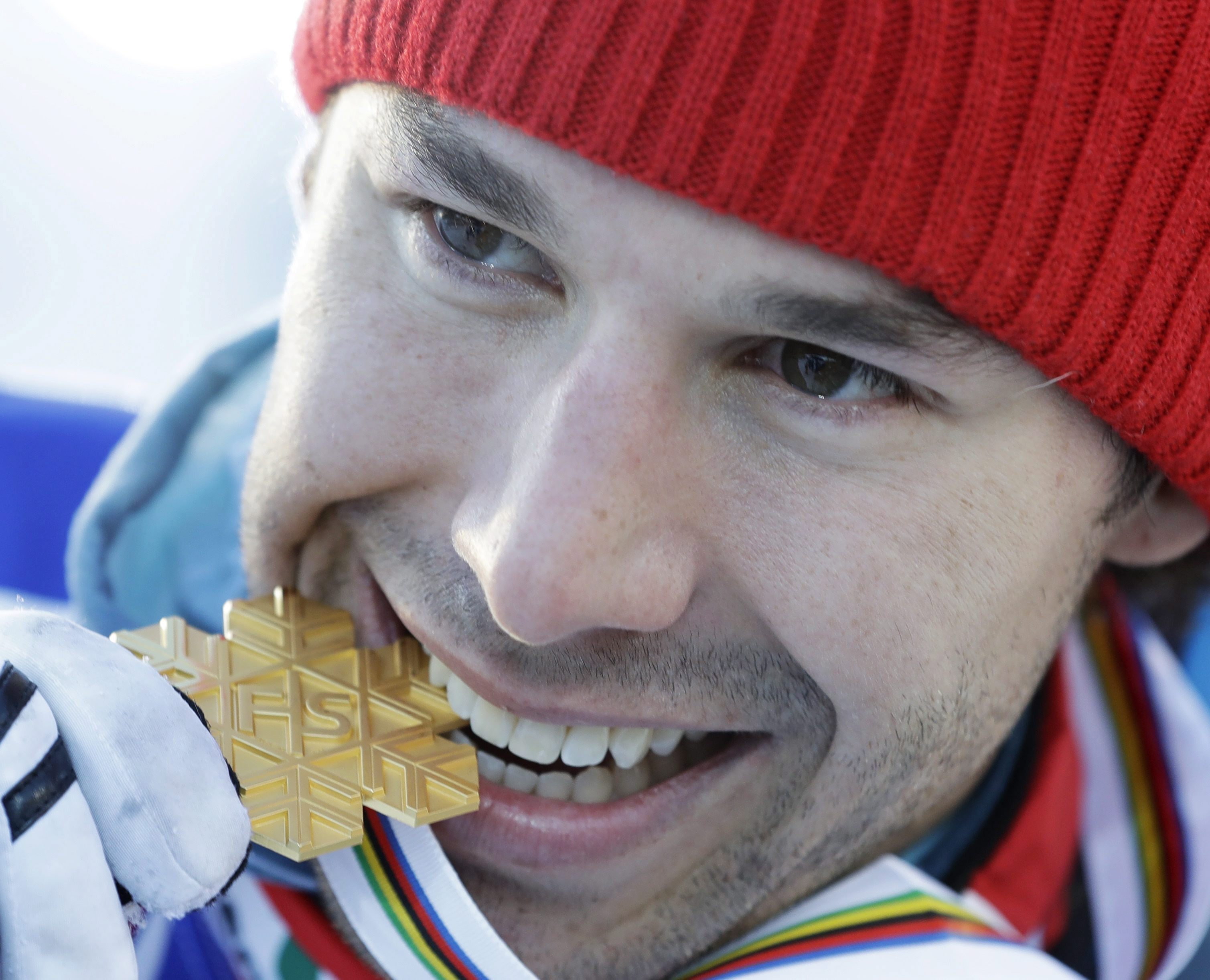 Canada's Alex Harvey bites his gold medal after winning the men's 50 km race during the 2017 Nordic Skiing World Championships in Lahti, Finland, Sunday, March 5, 2017. (AP Photo/Matthias Schrader)