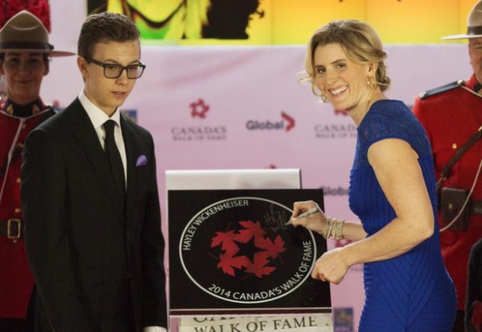 With the help of her son Noah Pacina, hockey Olympian Hayley Wickenheiser, right, is inducted into Canada's Walk of Fame in Toronto on Saturday, October 18, 2014. THE CANADIAN PRESS/Michelle Siu