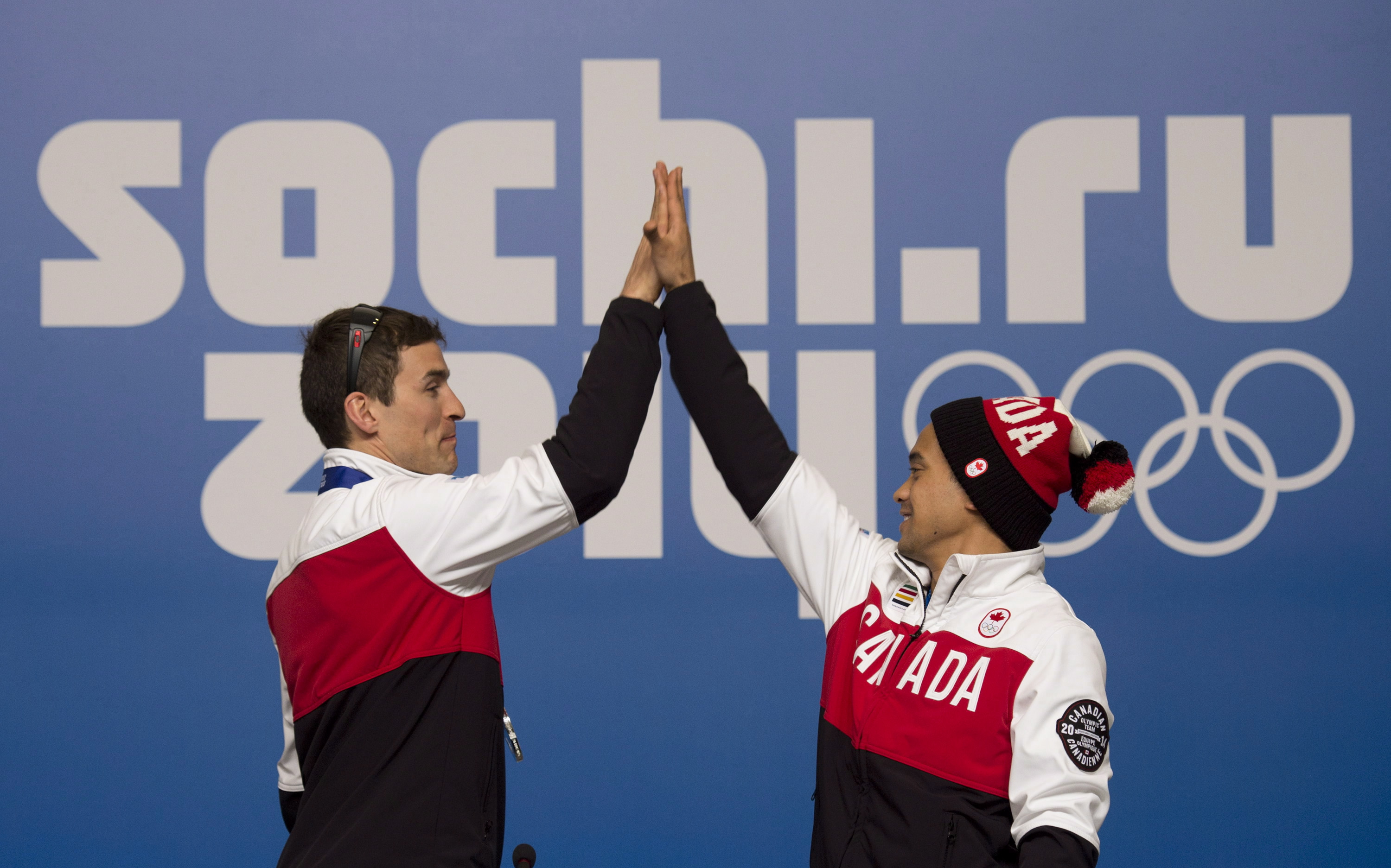 Canadian speed skaters Denny Morrison and Gilmore Junio perform their signature move following a a news conference at the Sochi Winter Olympics Sunday February 16, 2014 in Sochi, Russia. THE CANADIAN PRESS/Adrian Wyld
