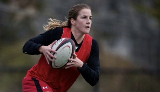 Nadia Popov runs with the ball during a rugby match.