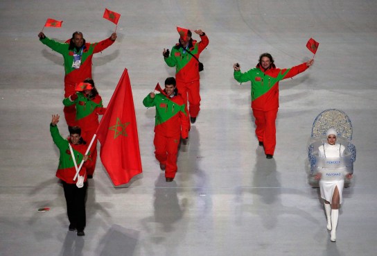 Adam Lamhamedi of Morocco holds his national flag and enters the arena with teammates during the opening ceremony of the 2014 Olympic Winter Games in Sochi, Russia, Friday, Feb. 7, 2014. (AP Photo/Charlie Riedel)