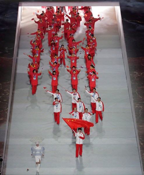 Tong Jian of China waves his national flag and enters the arena with teammates during the opening ceremony of the 2014 Winter Olympics in Sochi, Russia, Friday, Feb. 7, 2014. (AP Photo/Charlie Riedel)