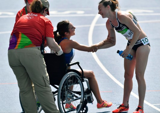 New Zealand's Nikki Hamblin greets United States' Abbey D'Agostino, left, as she is helped from the track after competing in a women's 5000-meter heat during the athletics competitions of the 2016 Summer Olympics at the Olympic stadium in Rio de Janeiro, Brazil, Tuesday, Aug. 16, 2016. (AP Photo/Martin Meissner)