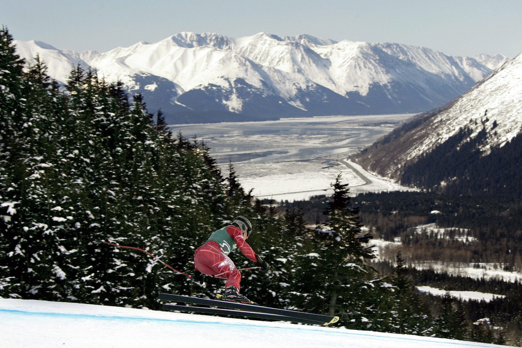 A skier races down the hill at Alyeska Resort in Girdwood, Alaska during the U.S. Alpine Championships, Thursday, March 29, 2007. Turnagain Arm, and Kenai Mountains are seen in the background. (AP Photo/Al Grillo)
