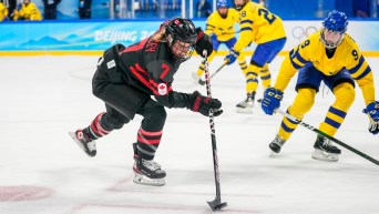 Laura Stacey plays the puck with her stick against Sweden