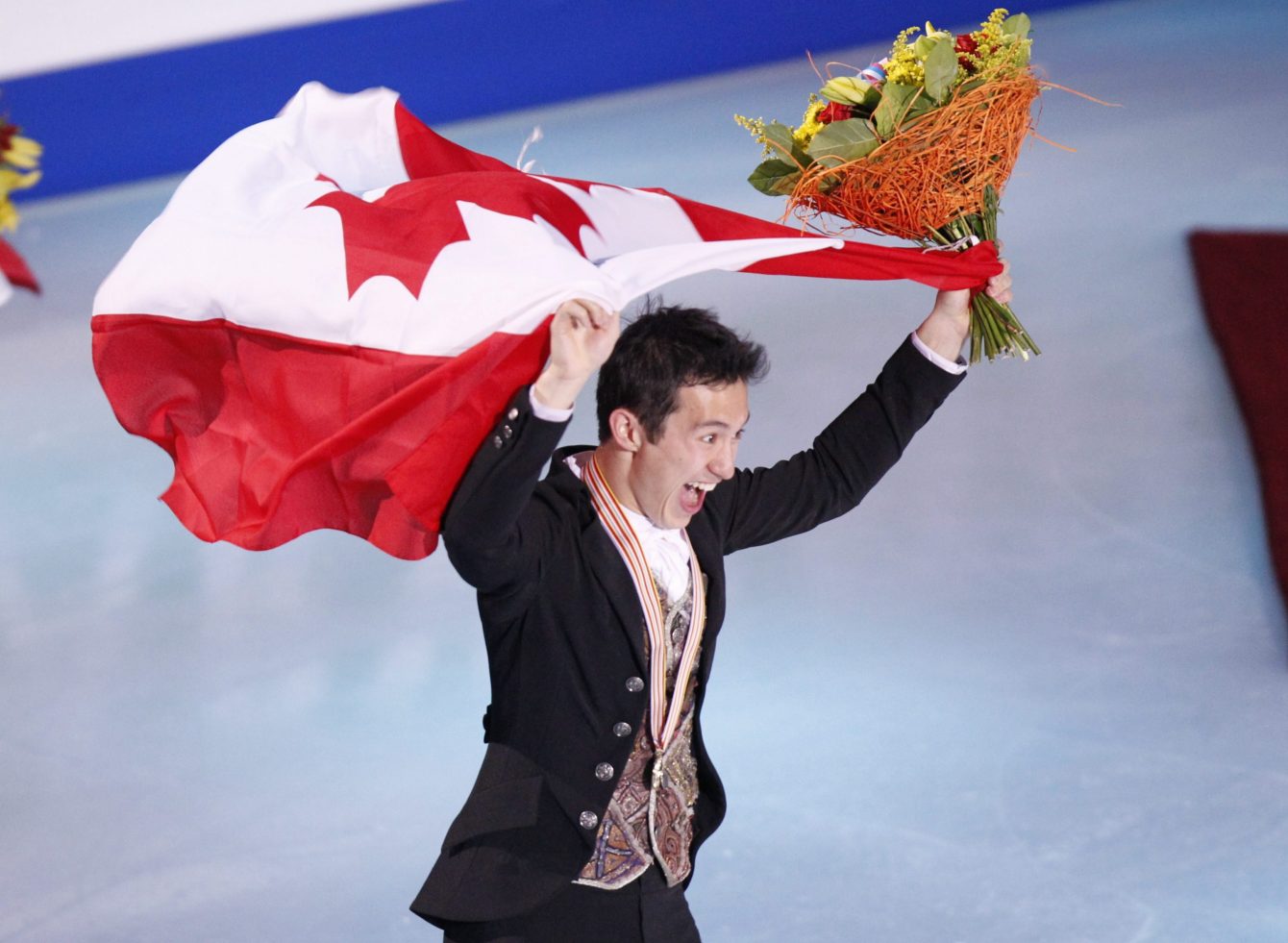Patrick Chan skates with the national flag