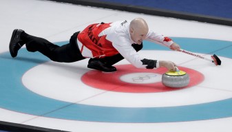 Kevin Koe throws a stone