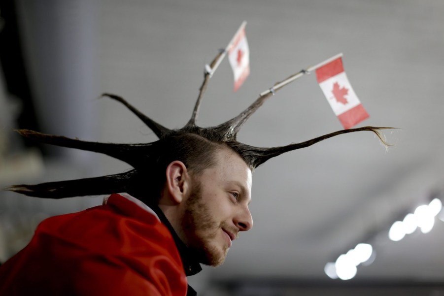 A spectator wearing the Canada flag on his hair watches the mixed doubles semi-final curling match between Russian athletes and Switzerland at the 2018 Winter Olympics in Gangneung, South Korea, Monday, Feb. 12, 2018. (AP Photo/Natacha Pisarenko)