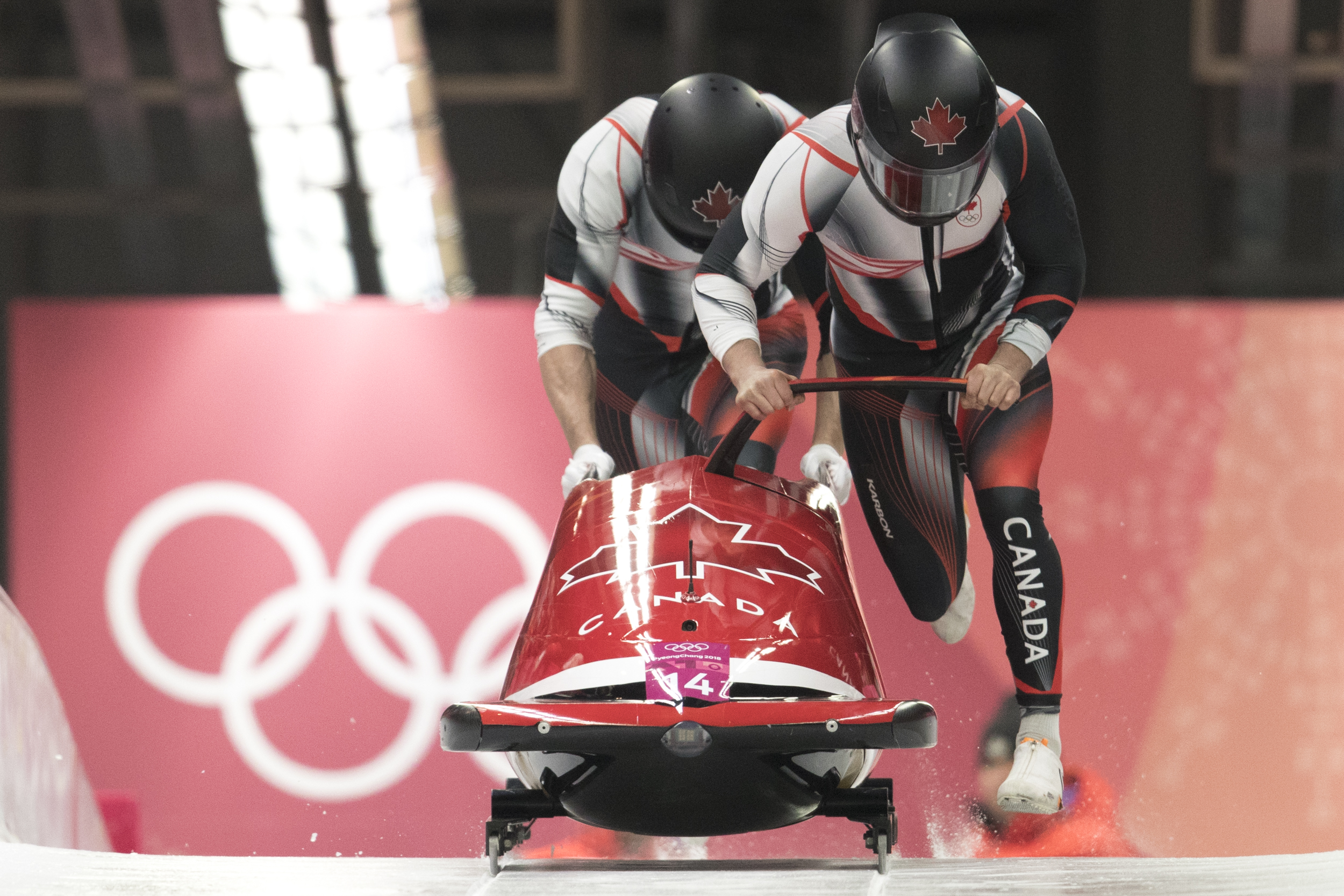 Bobsledders push two-man sled 