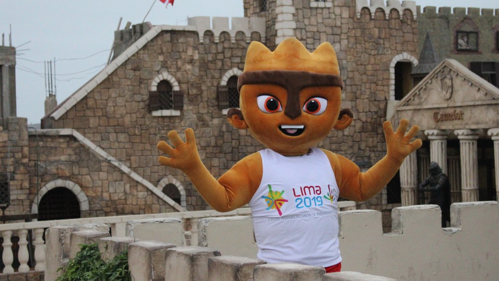 The Lima mascot standing in front of a castle like building