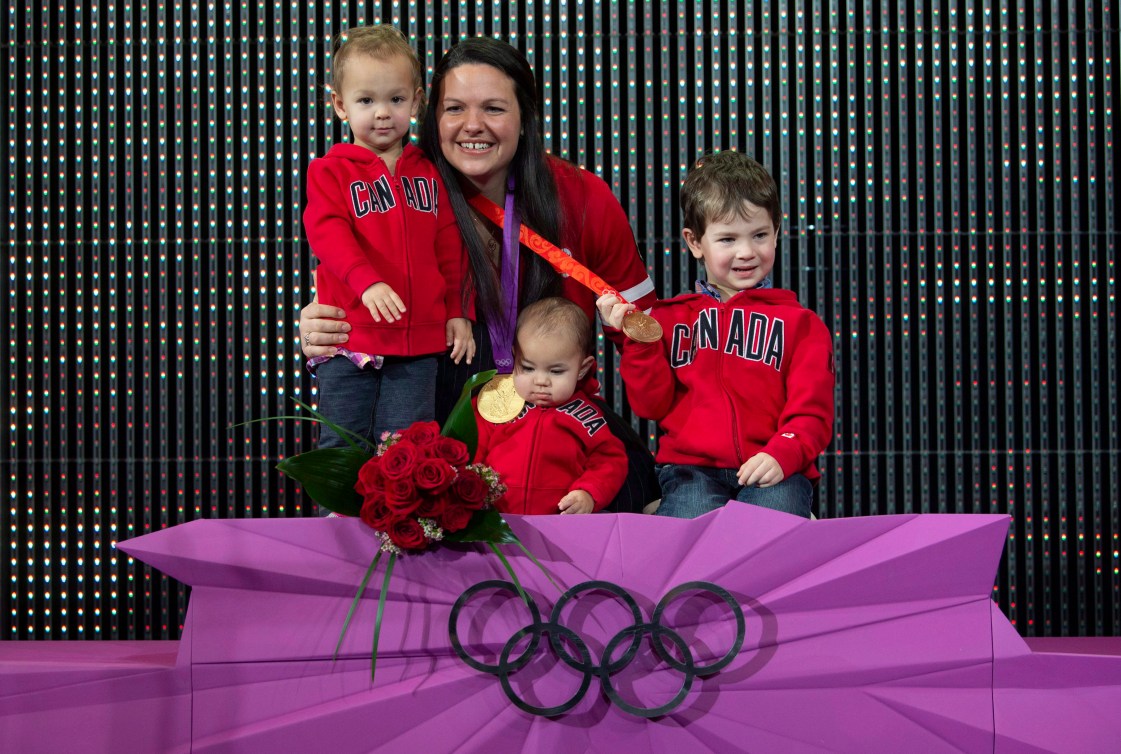 Christine Girard poses with her children on the podium with her gold and bronze medals 
