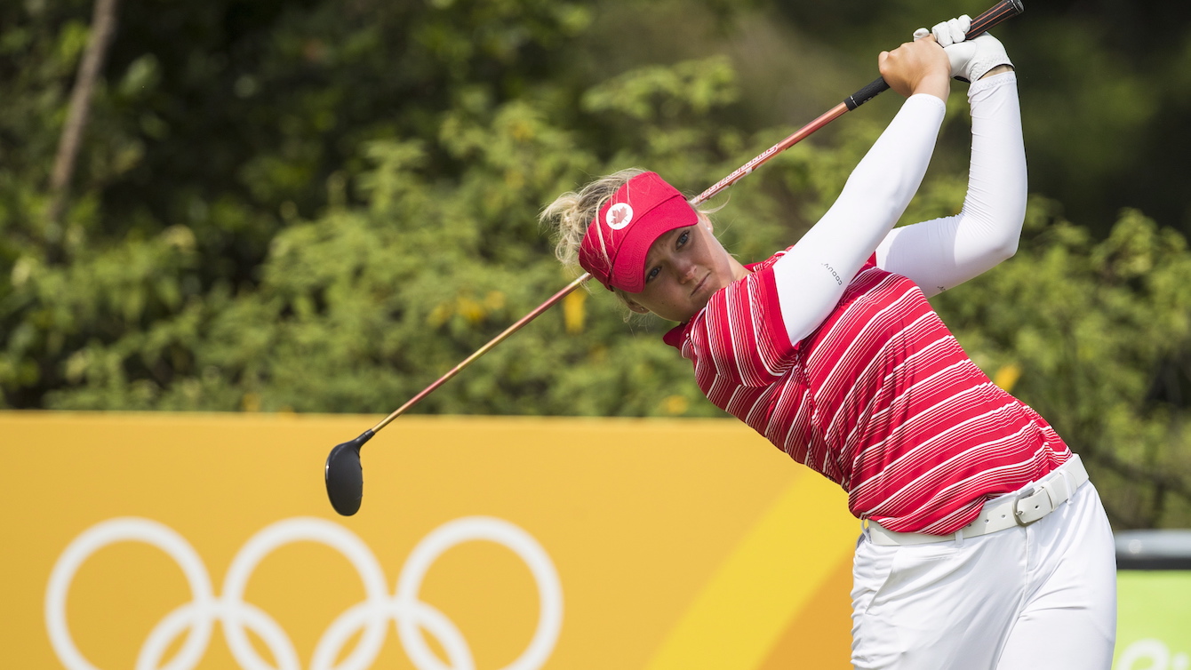 Brooke Henderson tees off in front of Olympic rings