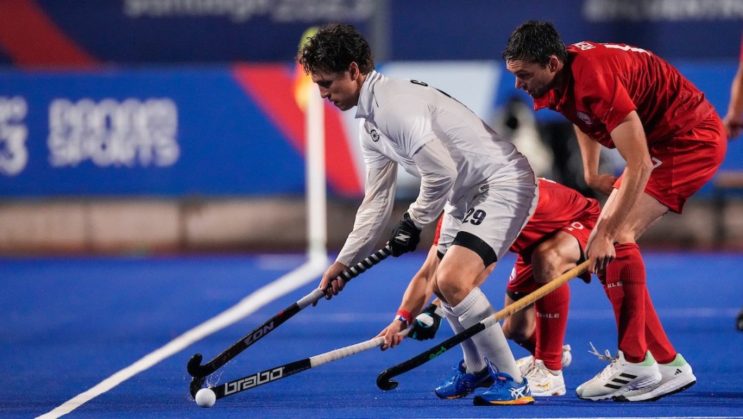 Two field hockey players battle for the ball