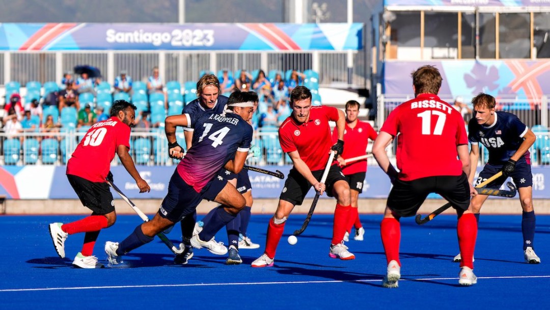 A group of field hockey players fight for the ball