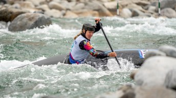 Lois Betteridge paddles her canoe in whitewater on a slalom course